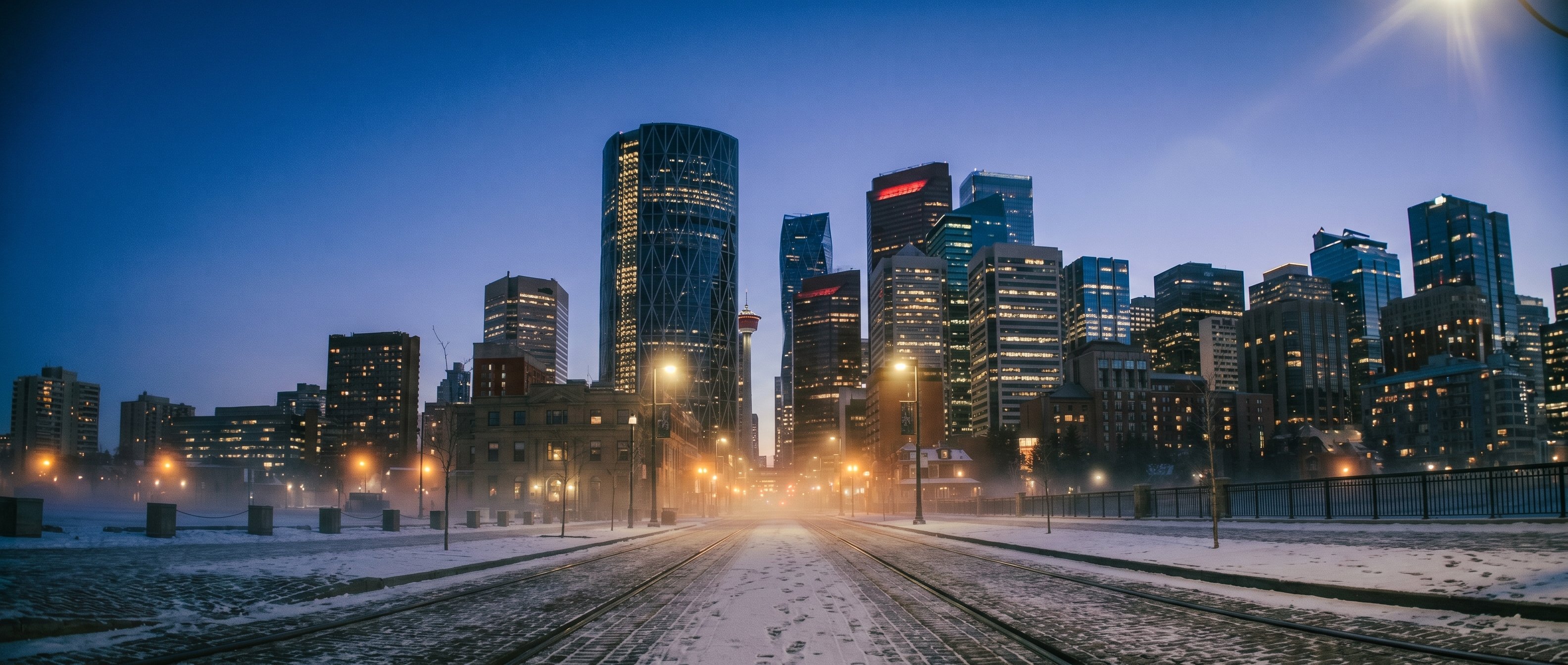 Downtown Calgary at blue hour, snow on Stephen Avenue with Bow Tower and Telus Sky in the distance