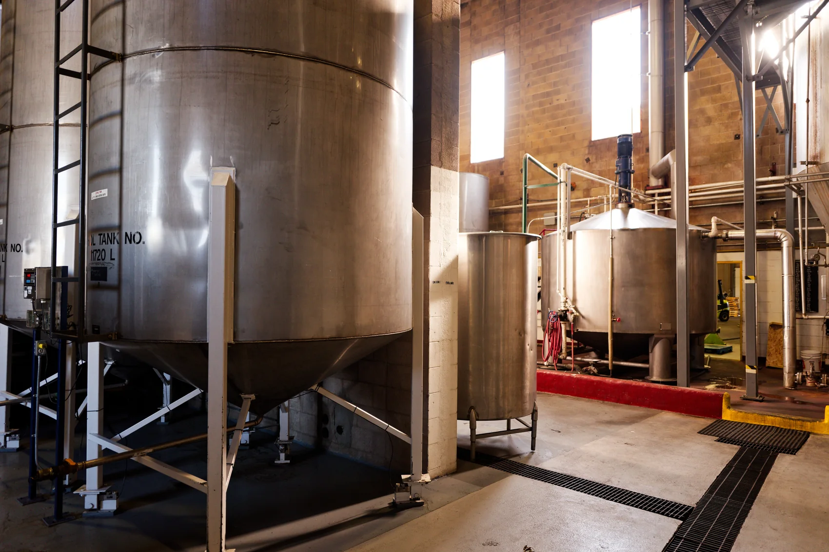 The still room, steel fermenting tanks beside the copper-topped still and its pipework. Photograph by Neville Palmer.
